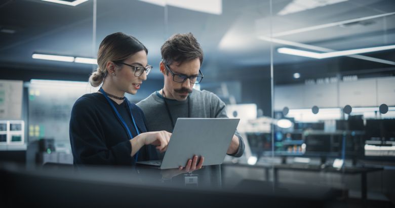 Two professionals reviewing digital content on a tablet in a modern work environment